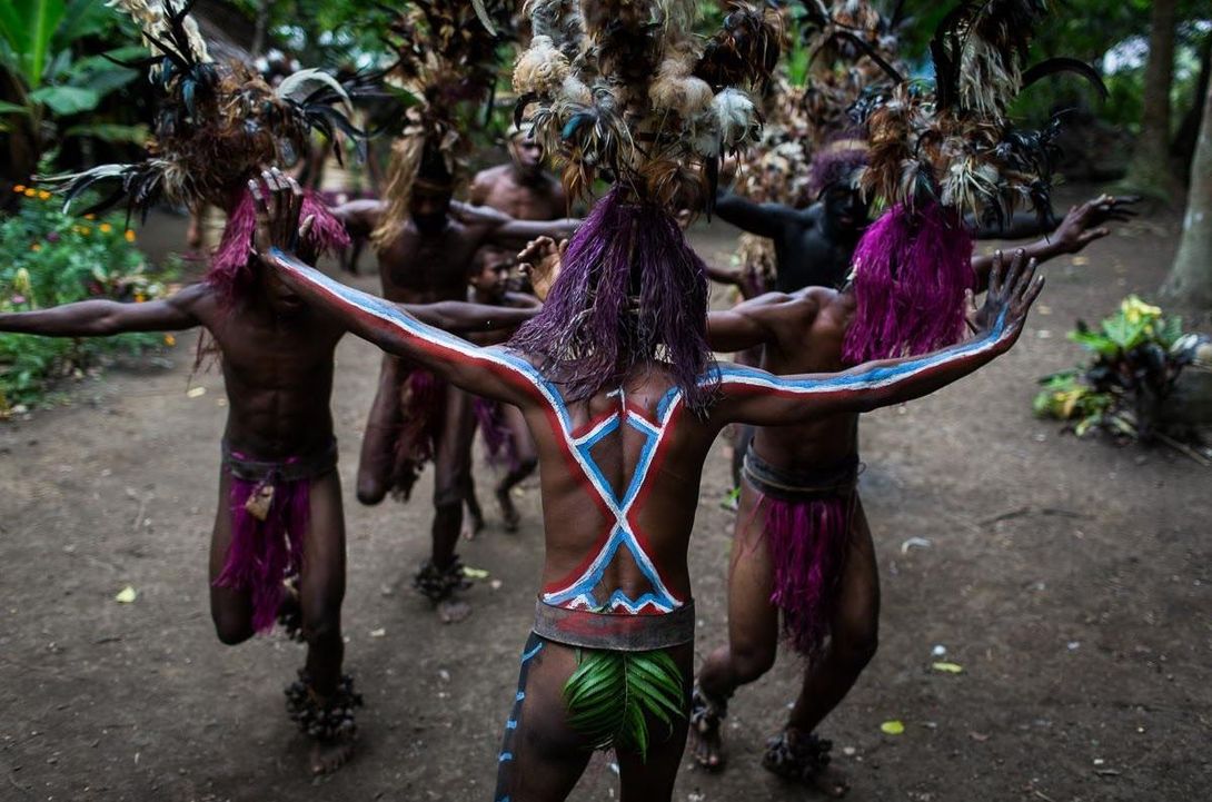 Person with prosthetic leg on tennis court, holding a racket.
