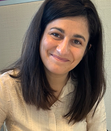 A woman wearing a black shirt is smiling for the camera