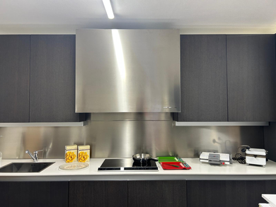 Una cucina con cappa in acciaio inox sopra i fornelli