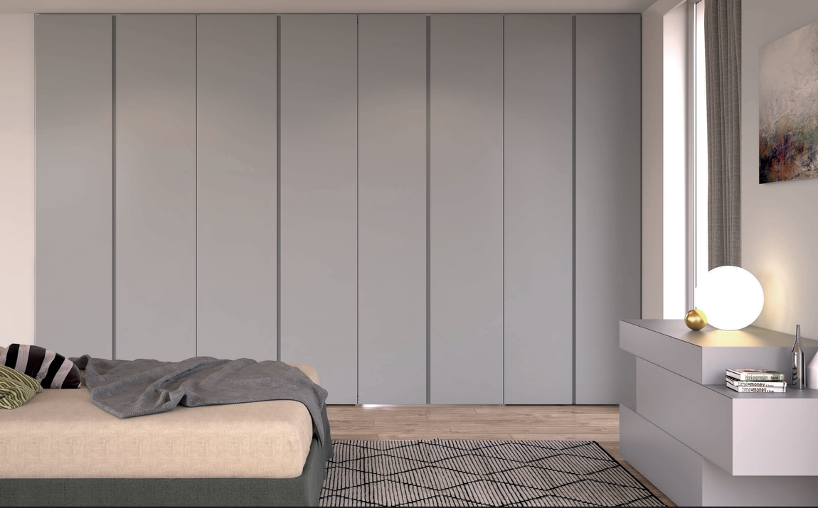 Una camera da letto con un letto, una sedia, una lampada e porte scorrevoli in vetro.
