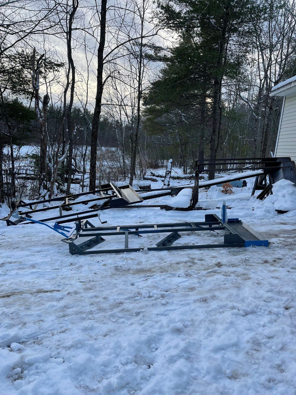 A snowmobile is parked in the snow in front of a house.