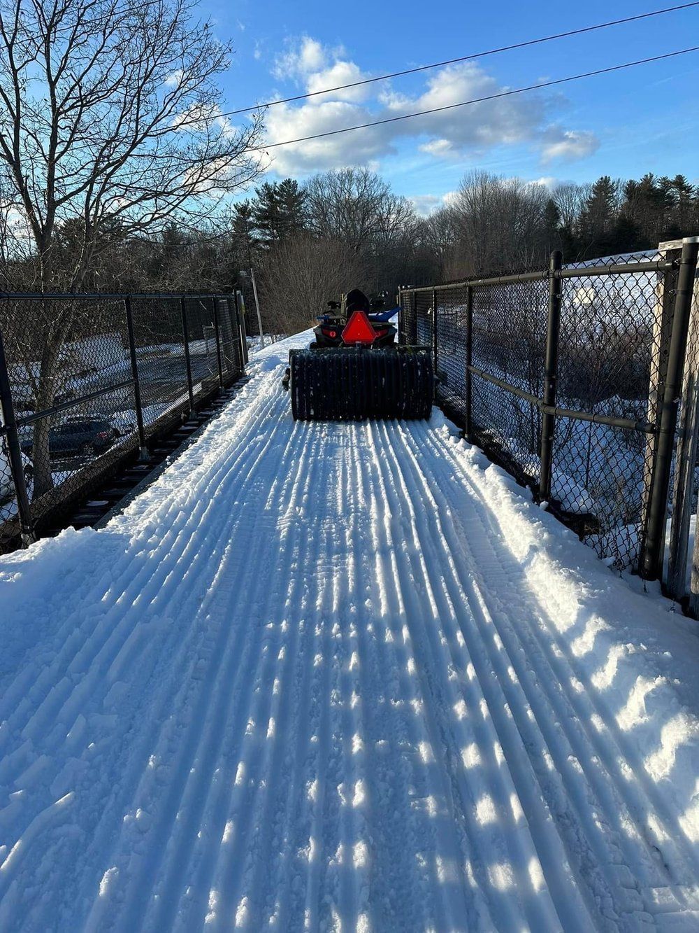 A person is riding a snowmobile on a snowy road.