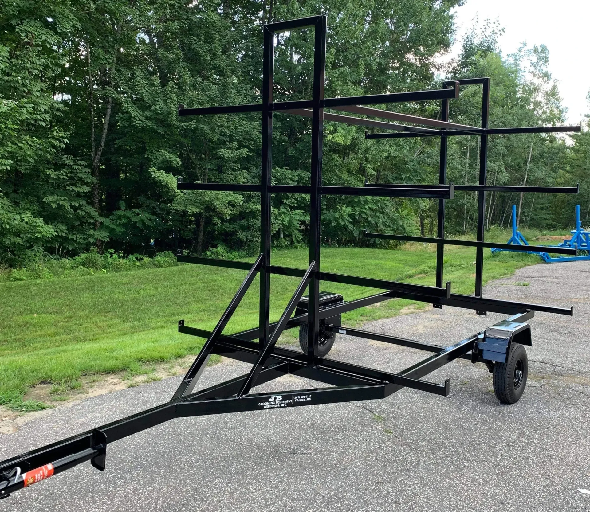 A trailer with a rack on it is parked on the side of the road.