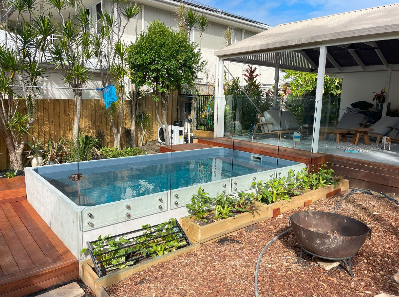A large Plungie swimming pool is in the backyard of a house. Semi above ground.