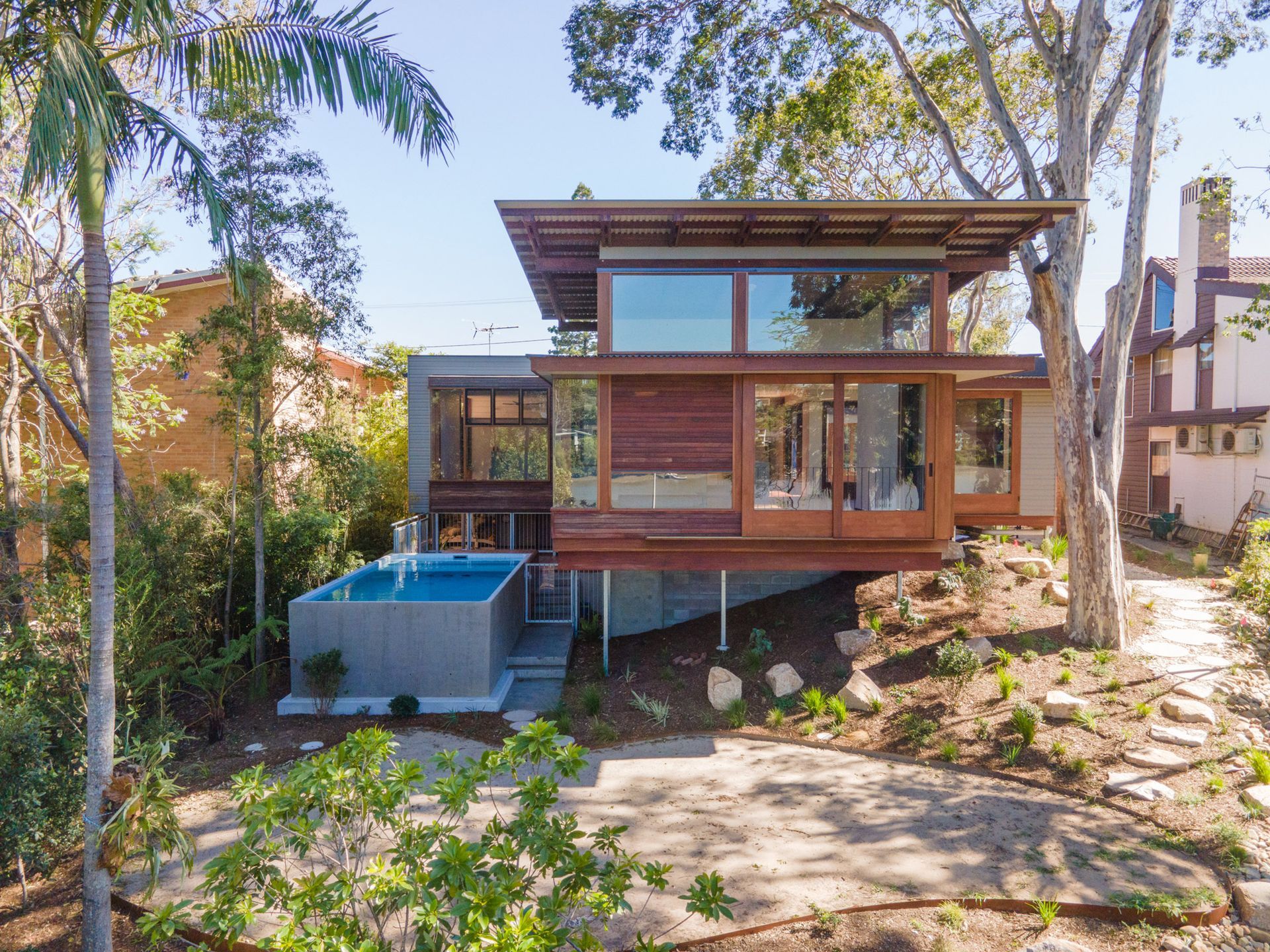 A modern house with a above ground Plungie swimming pool in front of it