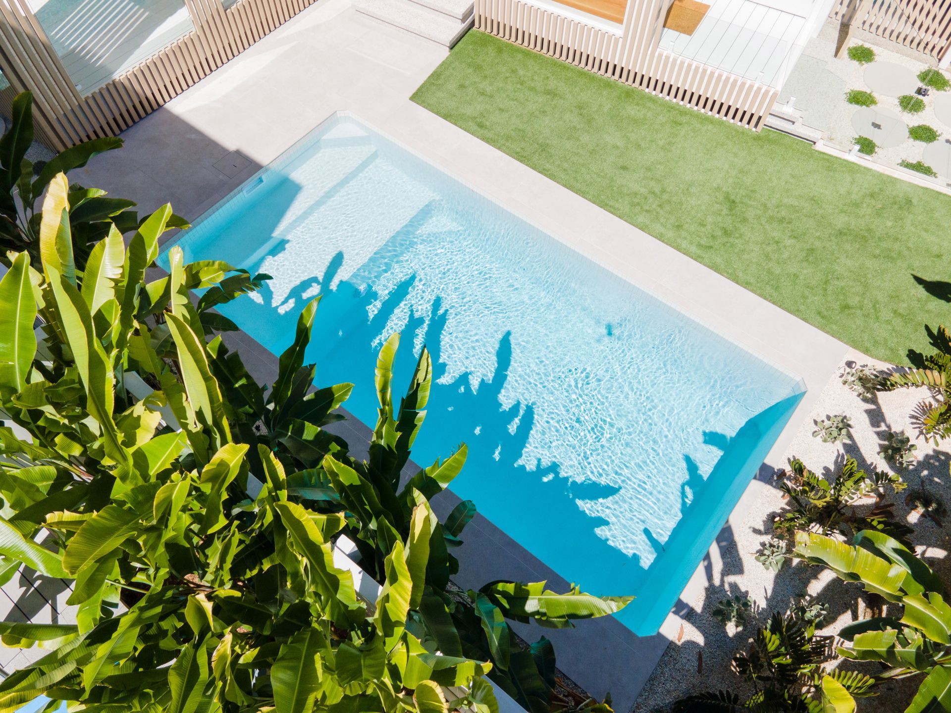 An aerial view of a Plungie Original swimming pool surrounded by trees and grass.