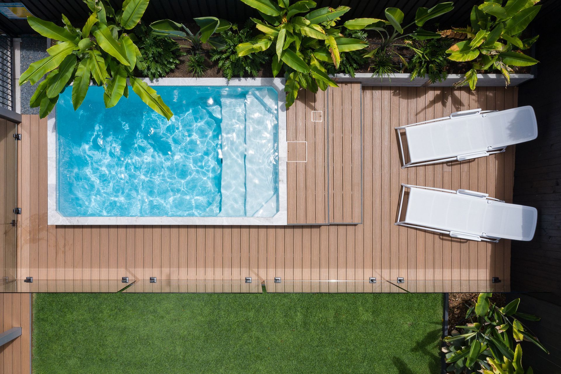 An aerial view of a backyard with a Plungie swimming pool and two lounge chairs.