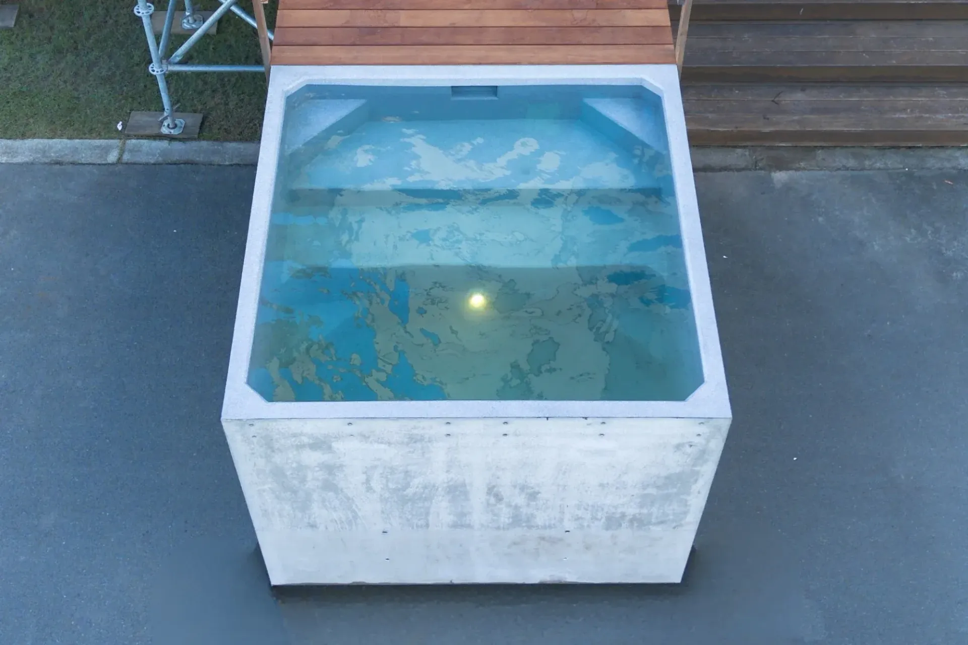 An aerial view of a square pre cast swimming pool, the Plungie Quad with a wooden deck.