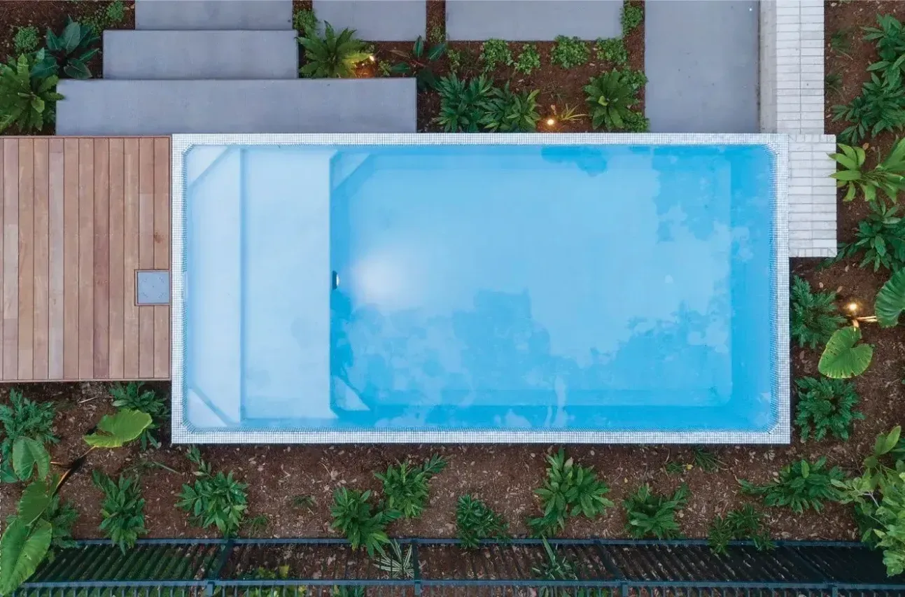An aerial view of a Plungie Max swimming pool surrounded by plants and stairs