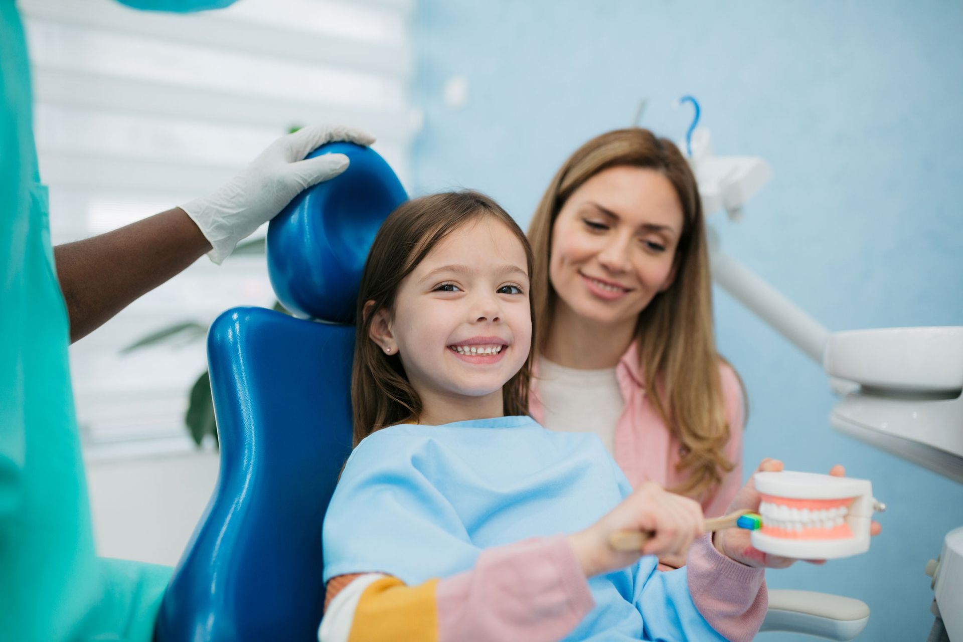 Little girl visiting a dentist for a check-up, smiling in dental chair