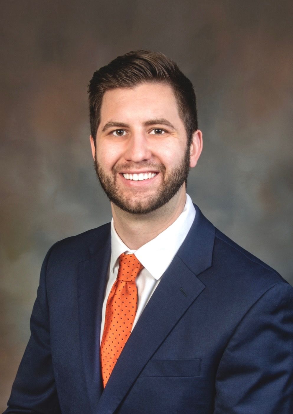 A man in a suit and tie is smiling for the camera.