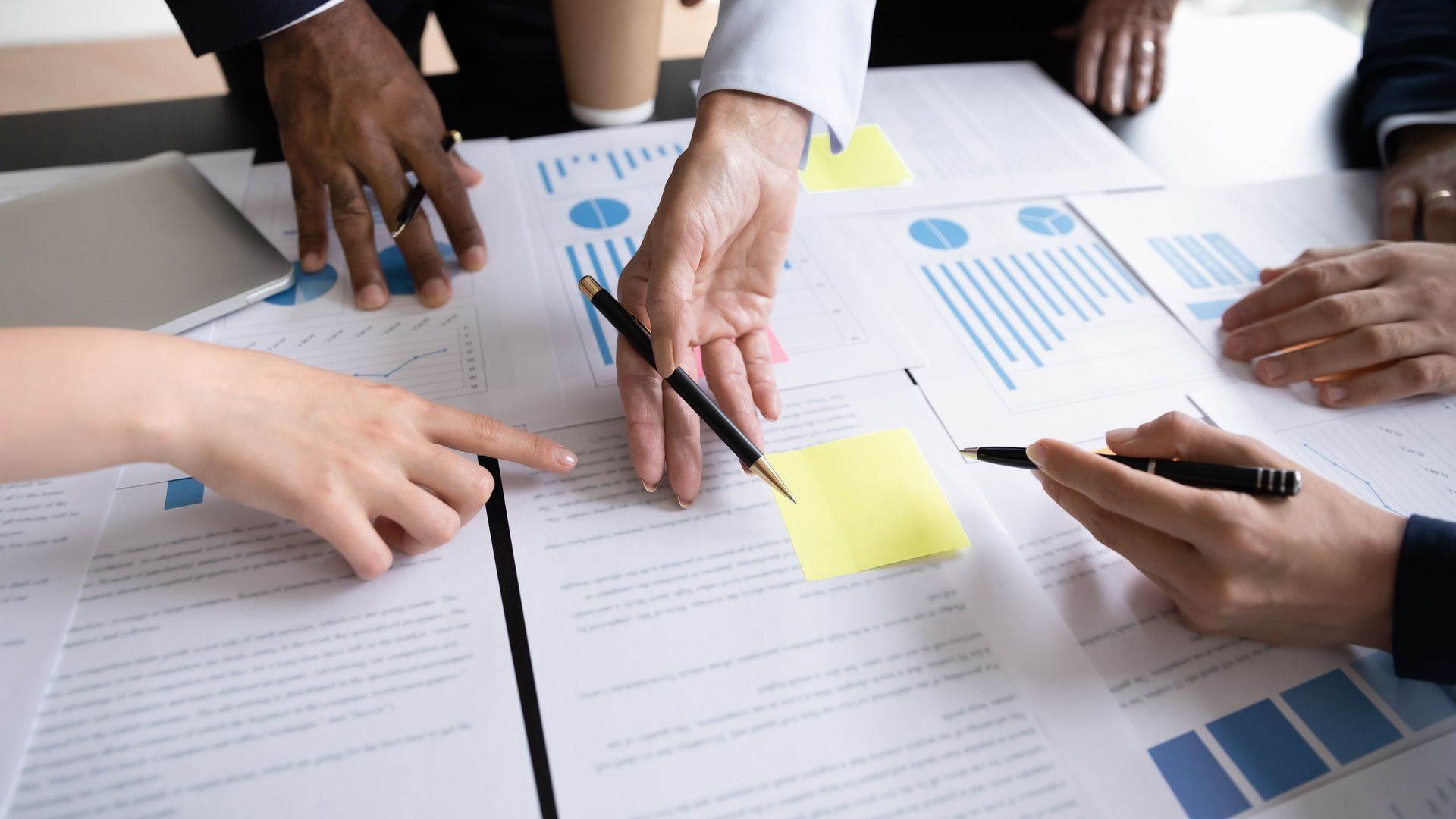 A group of people are sitting around a table looking at papers.