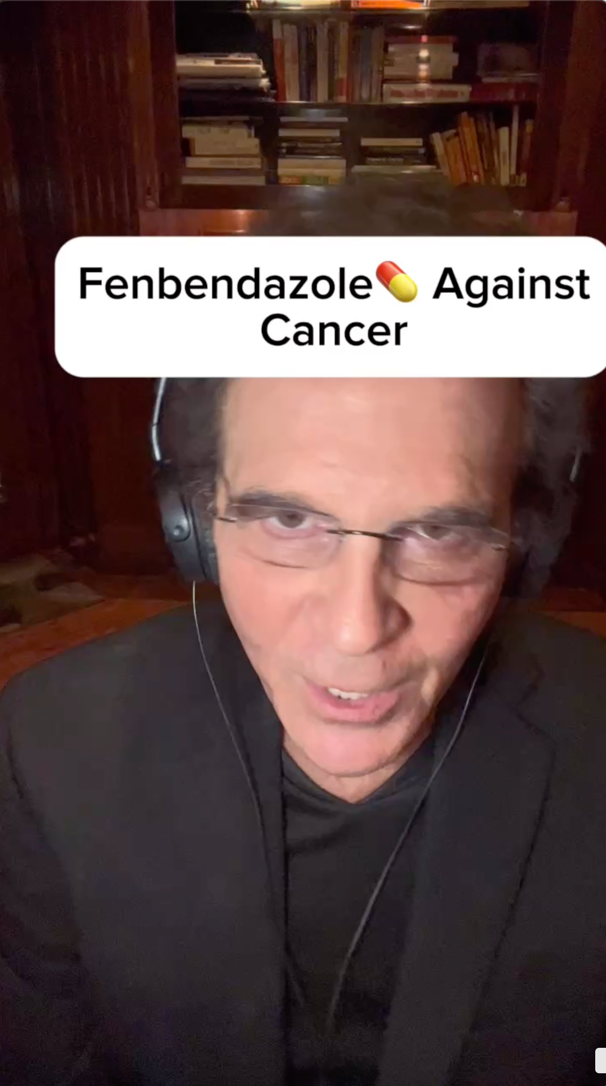 A man wearing headphones and glasses is talking about fenbendazole against cancer.