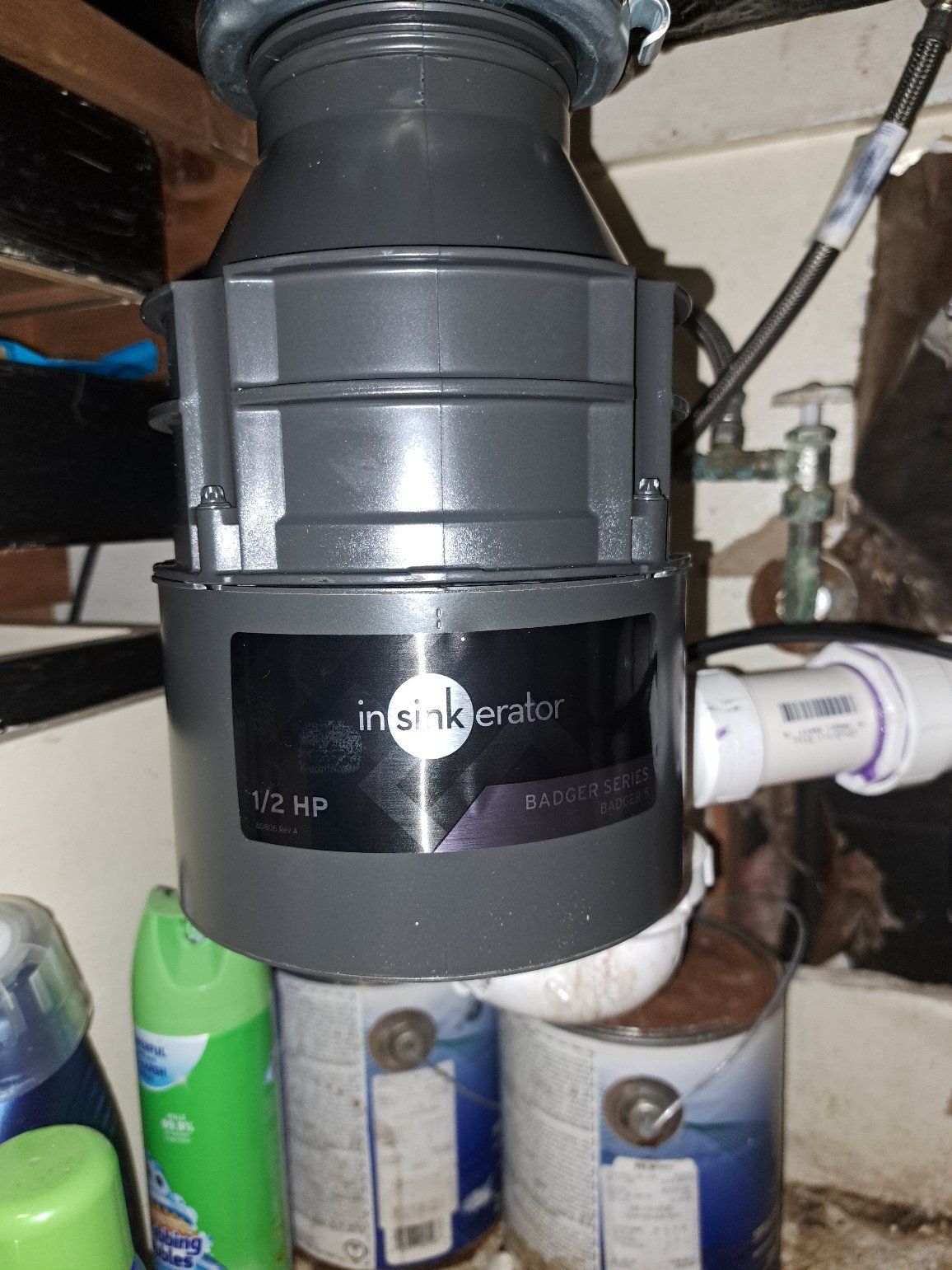 An Insinkerator garbage disposal unit installed under a kitchen sink.