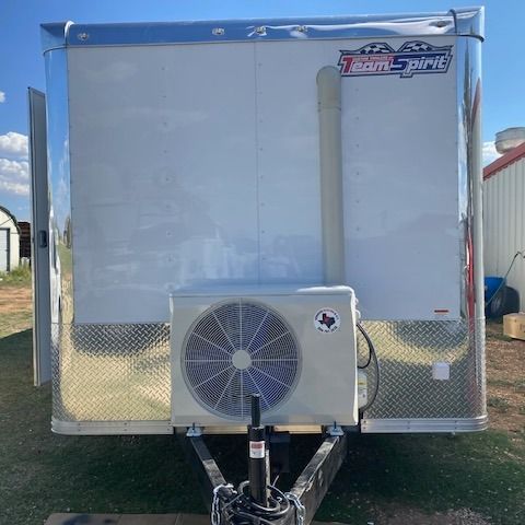 White trailer with an air conditioning unit and a Texas flag sticker.