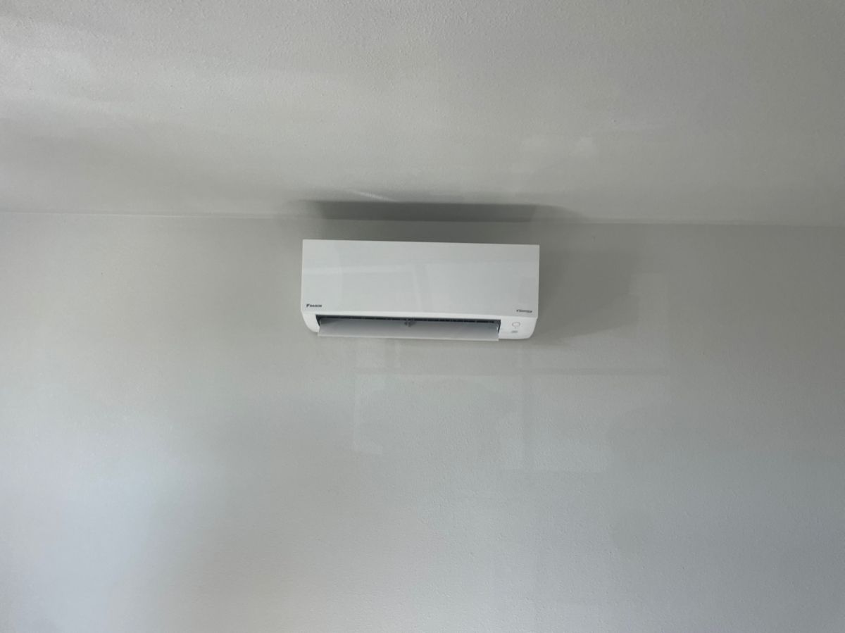 White air conditioning unit mounted on a light gray wall.