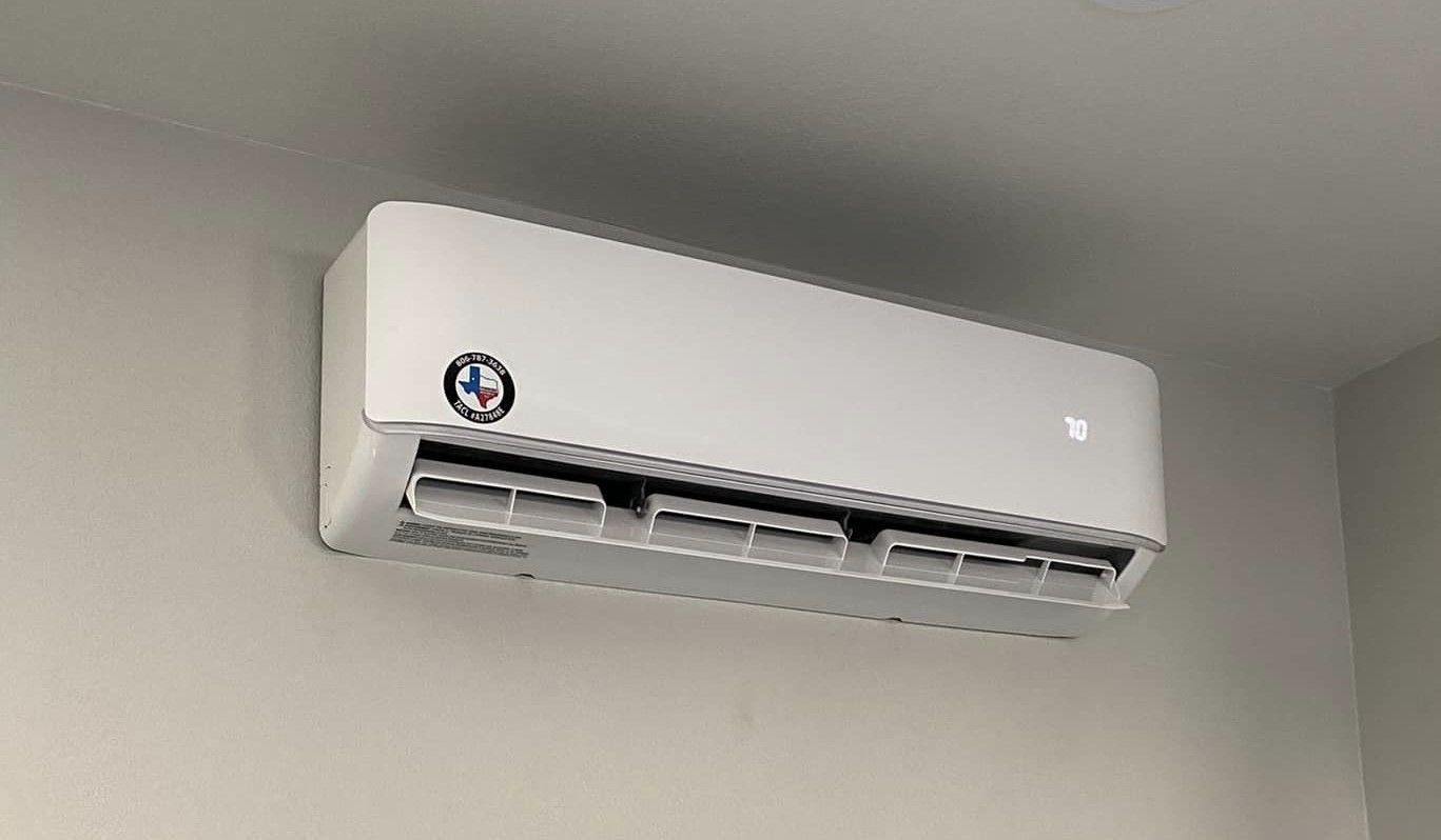 A white air conditioner is hanging from the ceiling in a room.