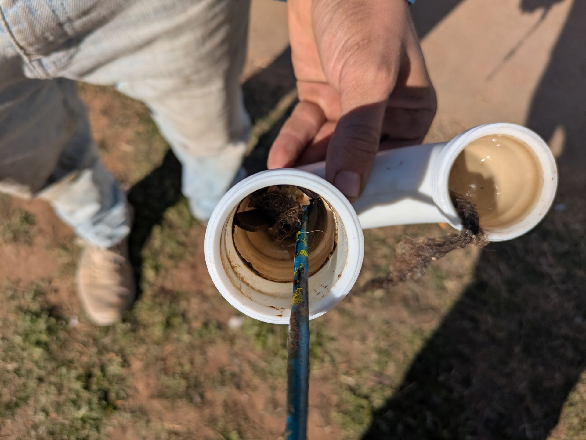 A person is holding two plastic pipes in their hands.