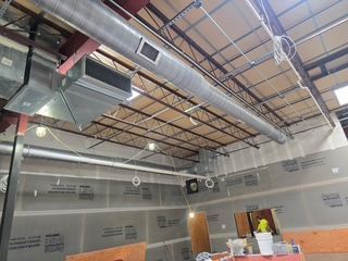 A large room with a lot of pipes hanging from the ceiling.