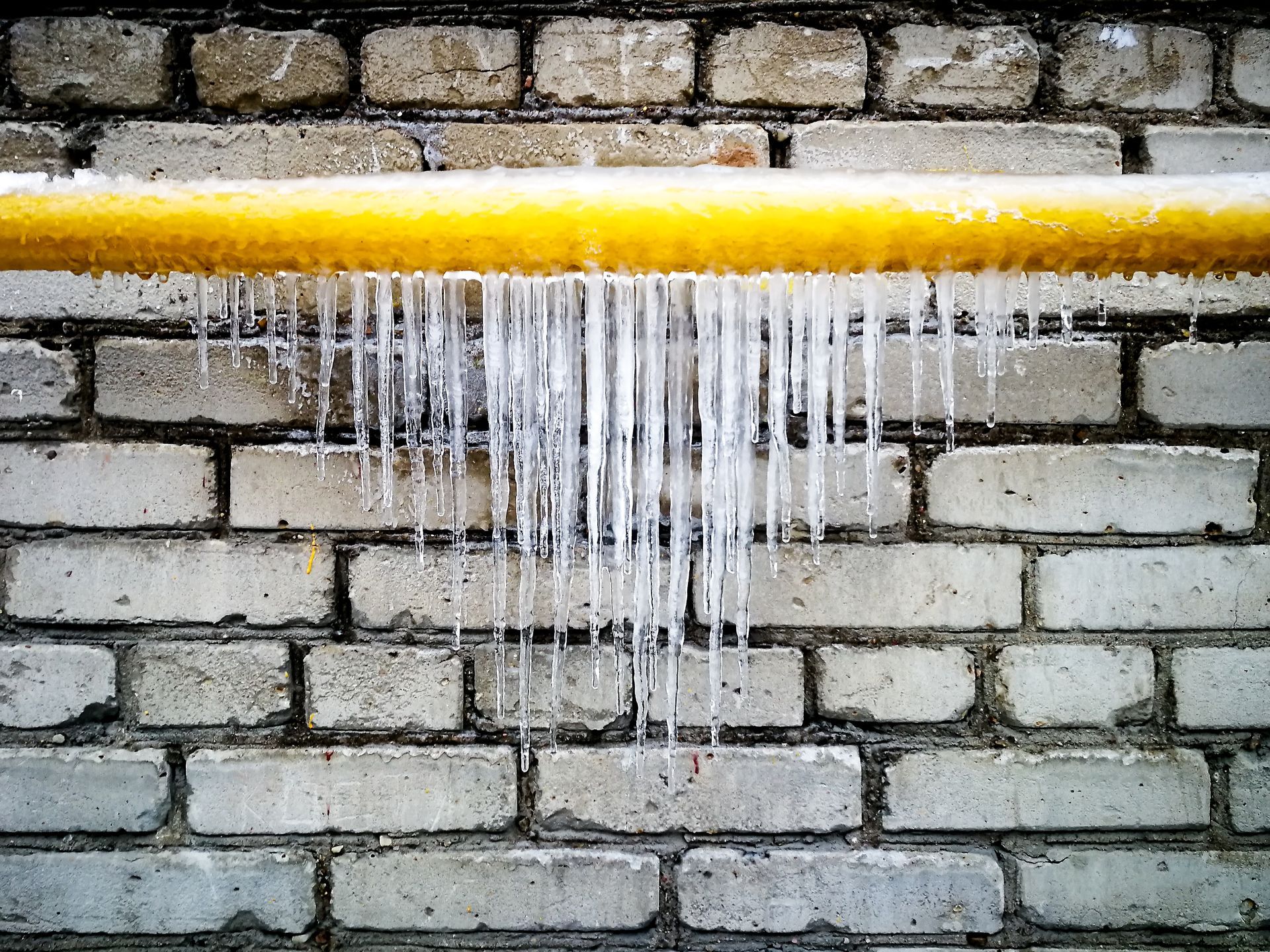 Icicles are hanging from a frozen water pipe