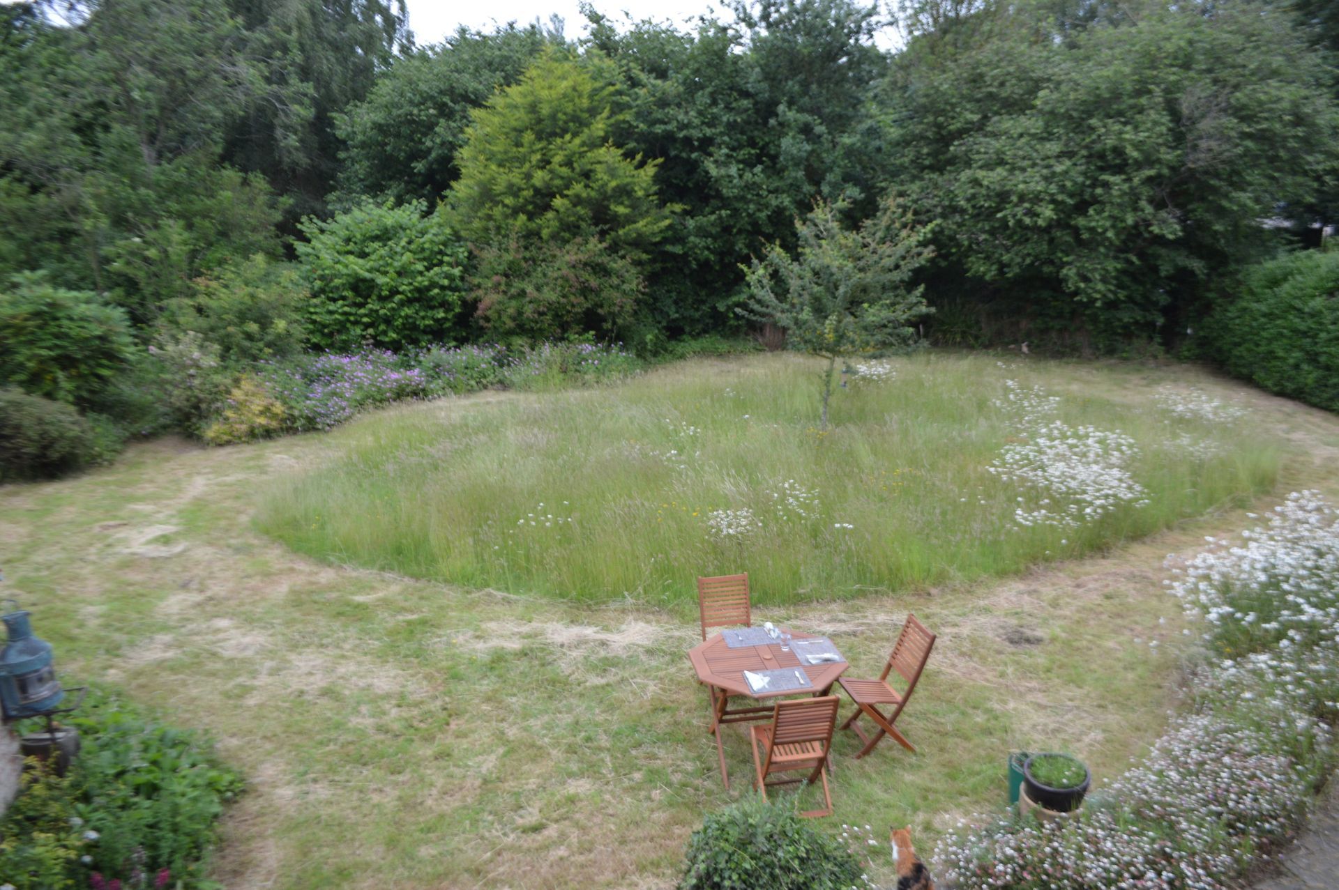 There is a table and chairs in the middle of the grass.