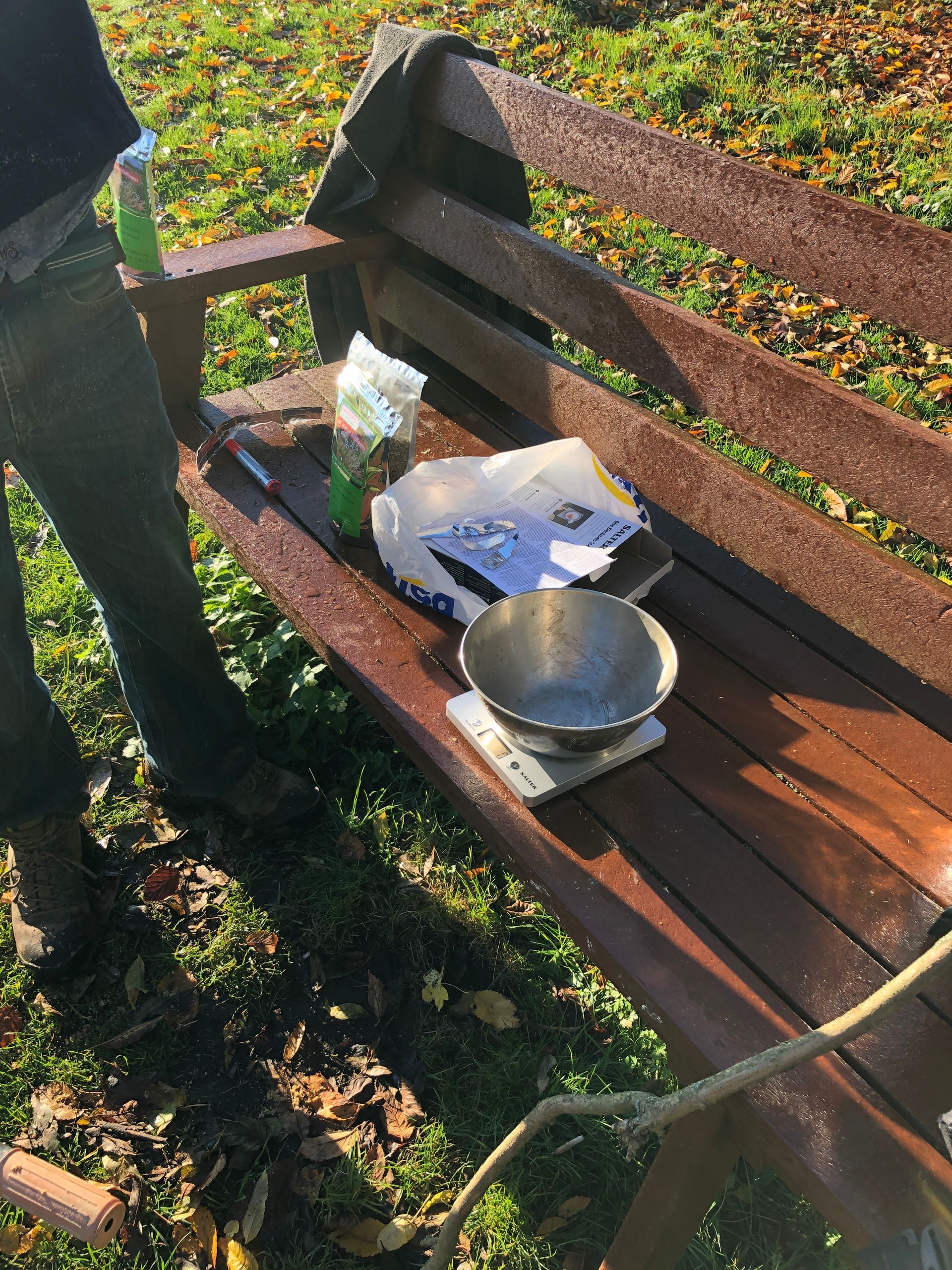 A person standing next to a wooden bench with a scale on it