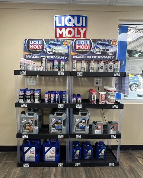 A display of Liqui Moly automotive products in a store setting. Various oil containers and bottles on shelves.