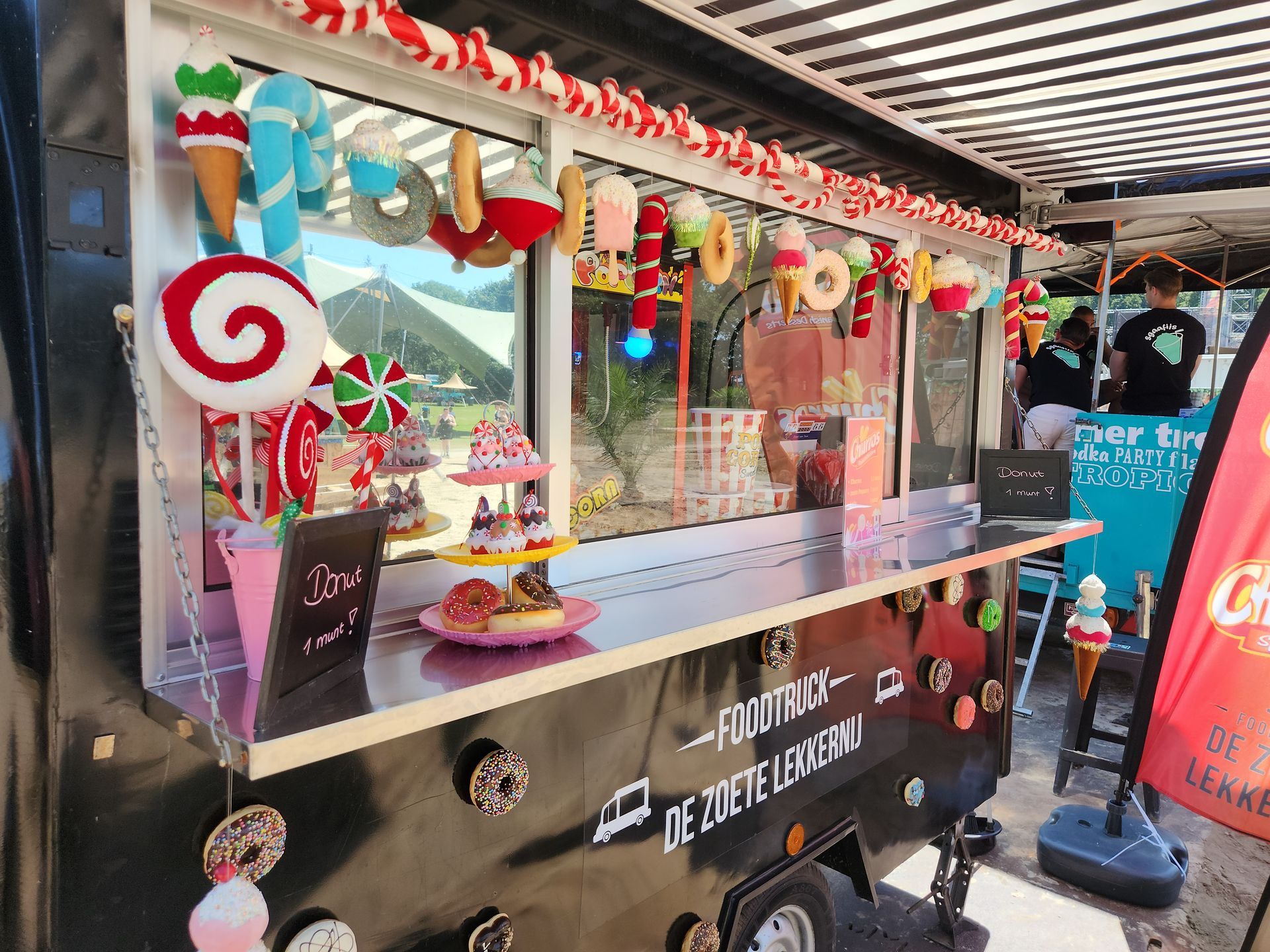 Een foodtruck is versierd met snoep en ijshoorntjes.