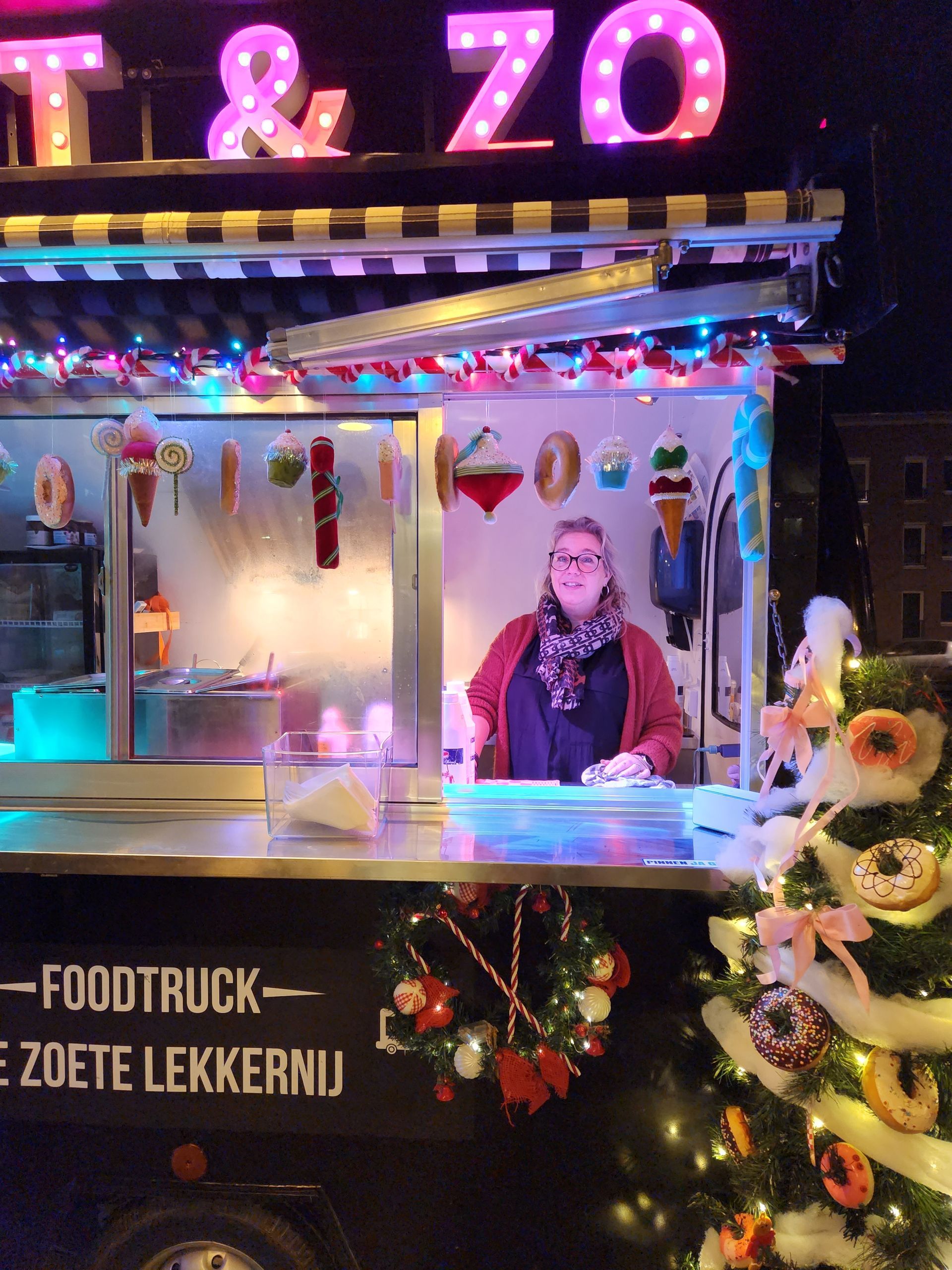 Een vrouw staat voor een foodtruck met de tekst t & zo