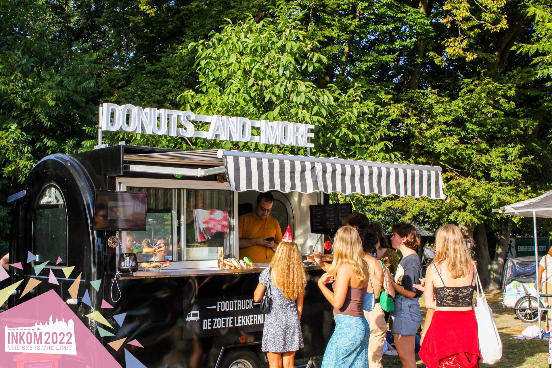Een groep mensen staat voor een foodtruck.