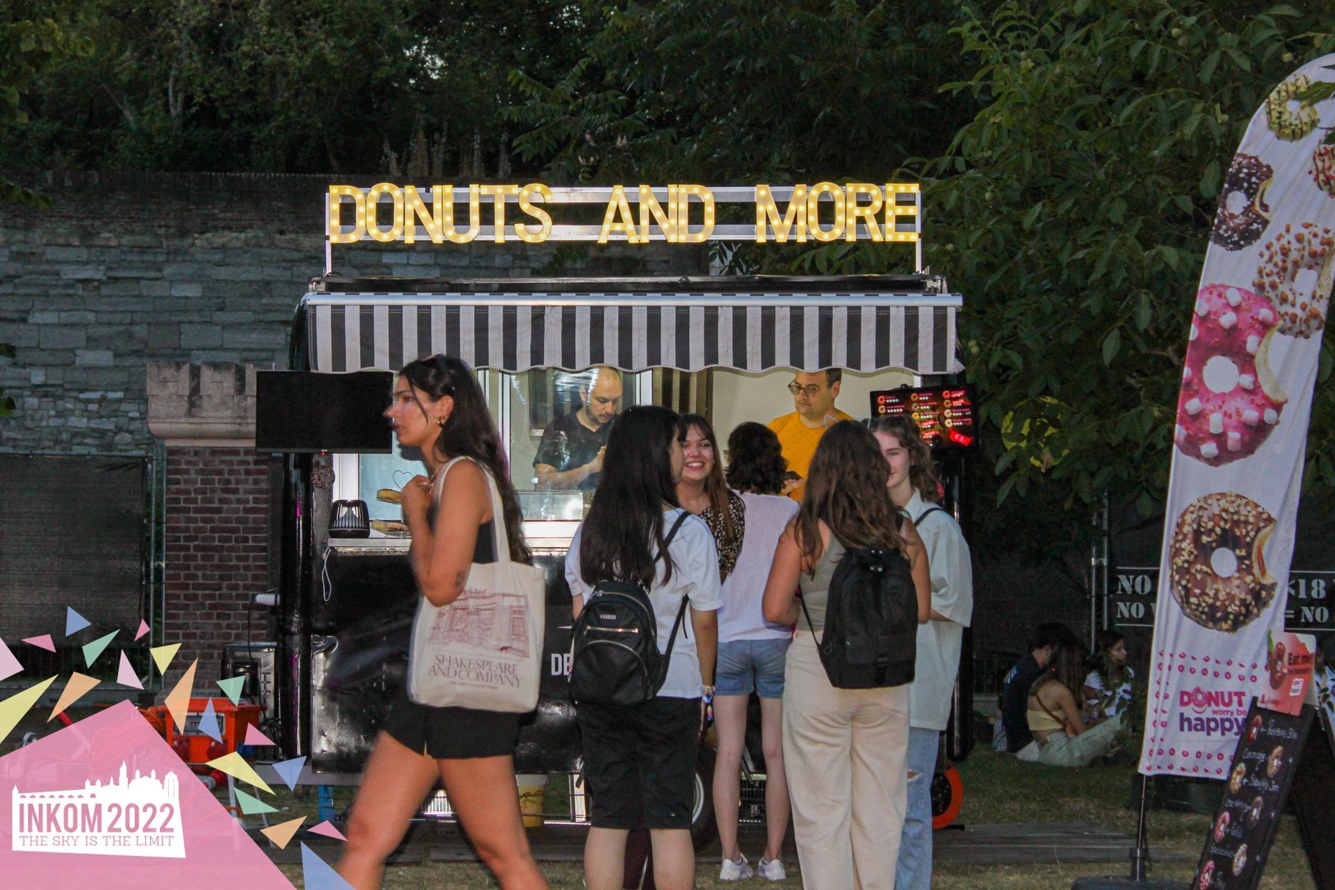 Een groep mensen staat voor een donuts en er staan ​​er nog meer.