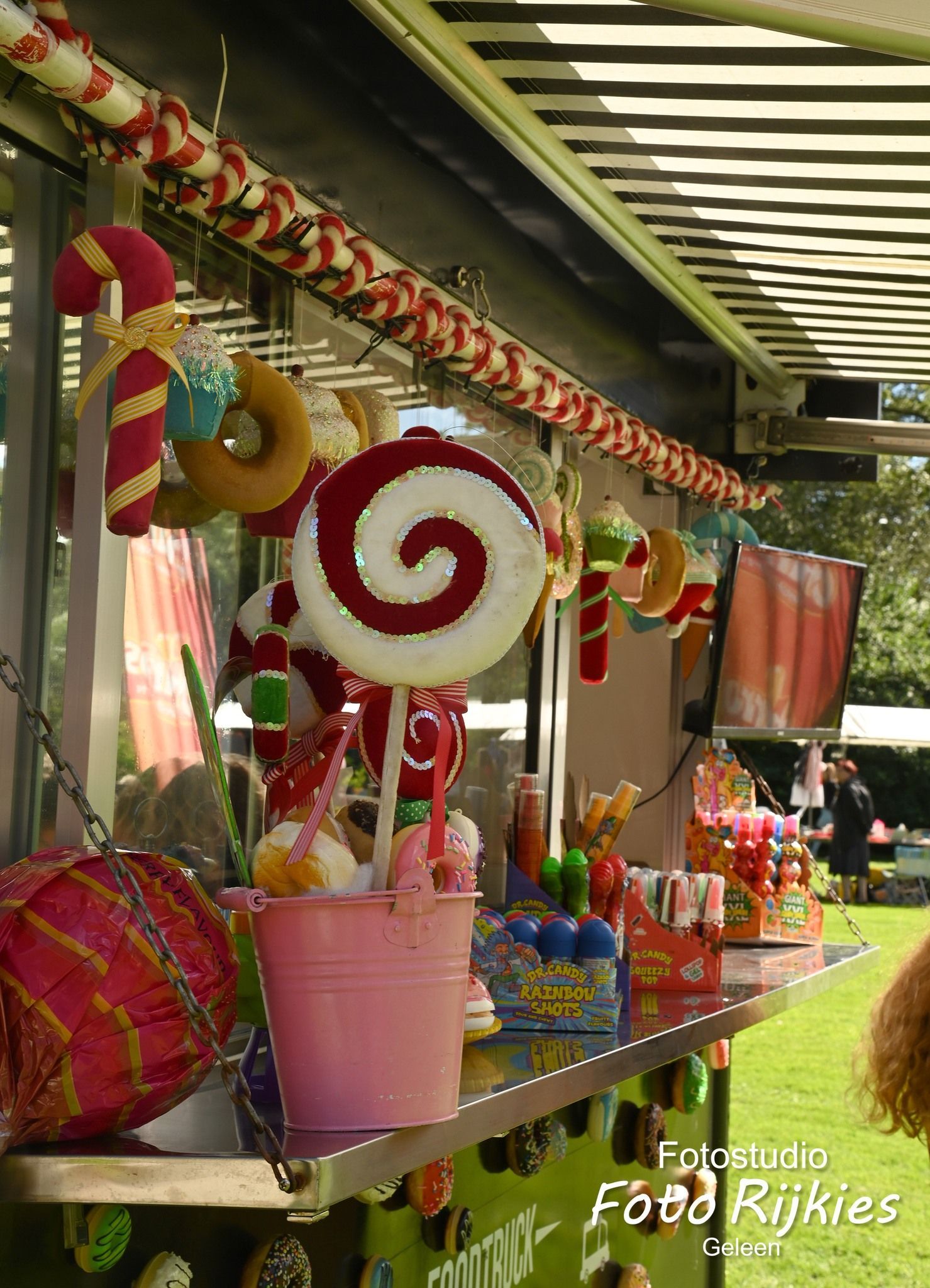 Een foodtruck versierd met zuurstokken en lolly's.