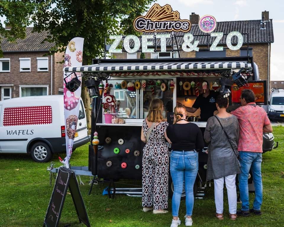 Een groep mensen staat voor een foodtruck met de tekst zoet & zo.
