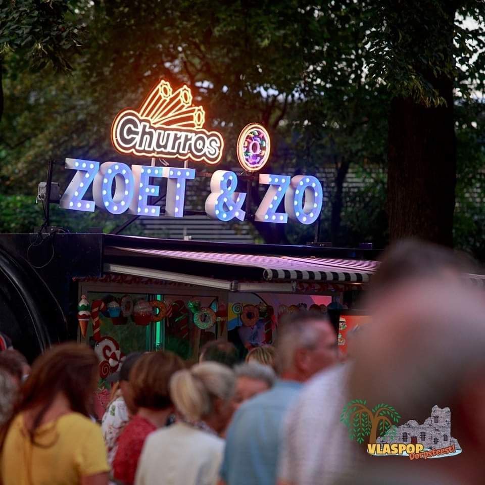 Een groep mensen staat voor een bord met de tekst churros zoet & zo