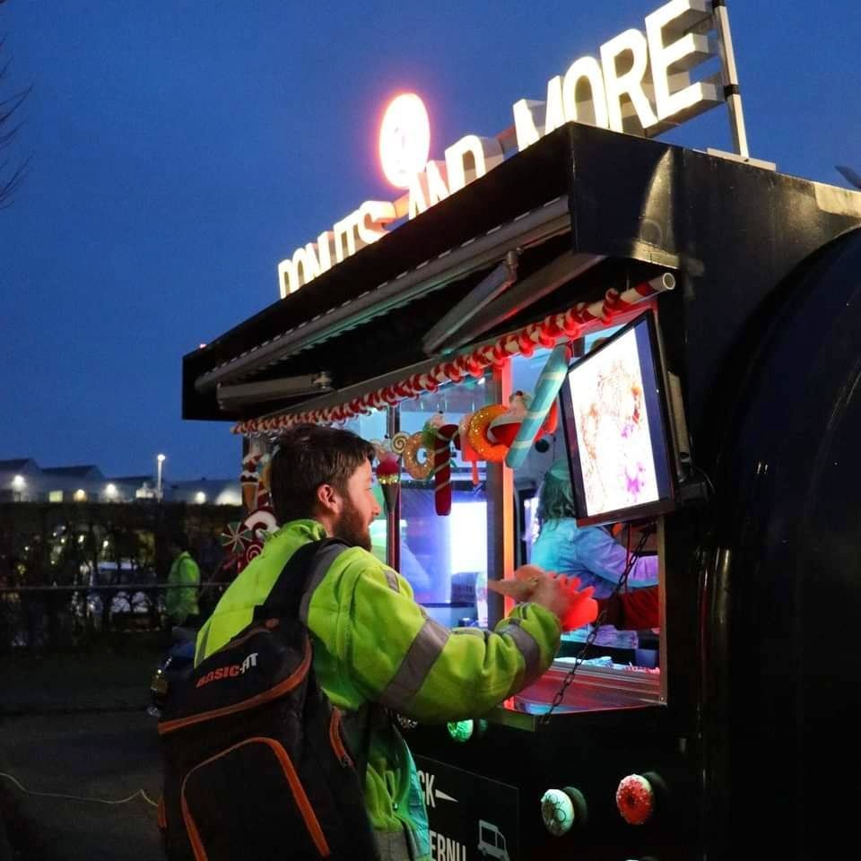 Een man die voor een donuts- en meerstand staat