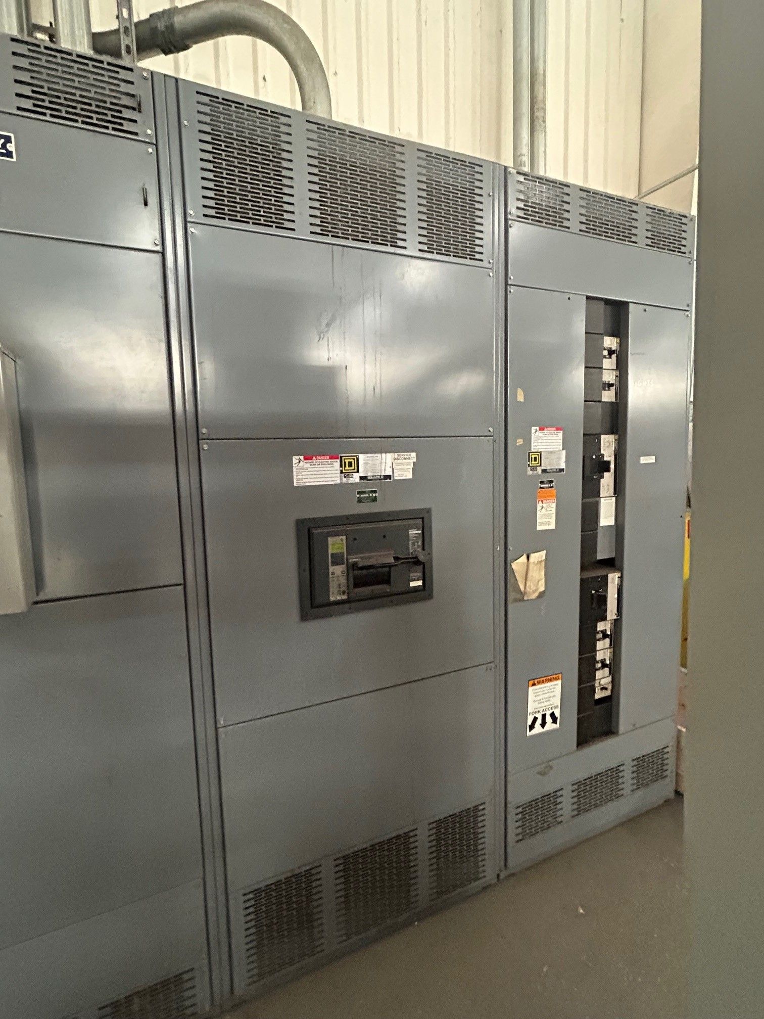 Gray electrical cabinet with ventilation grates and control panel.