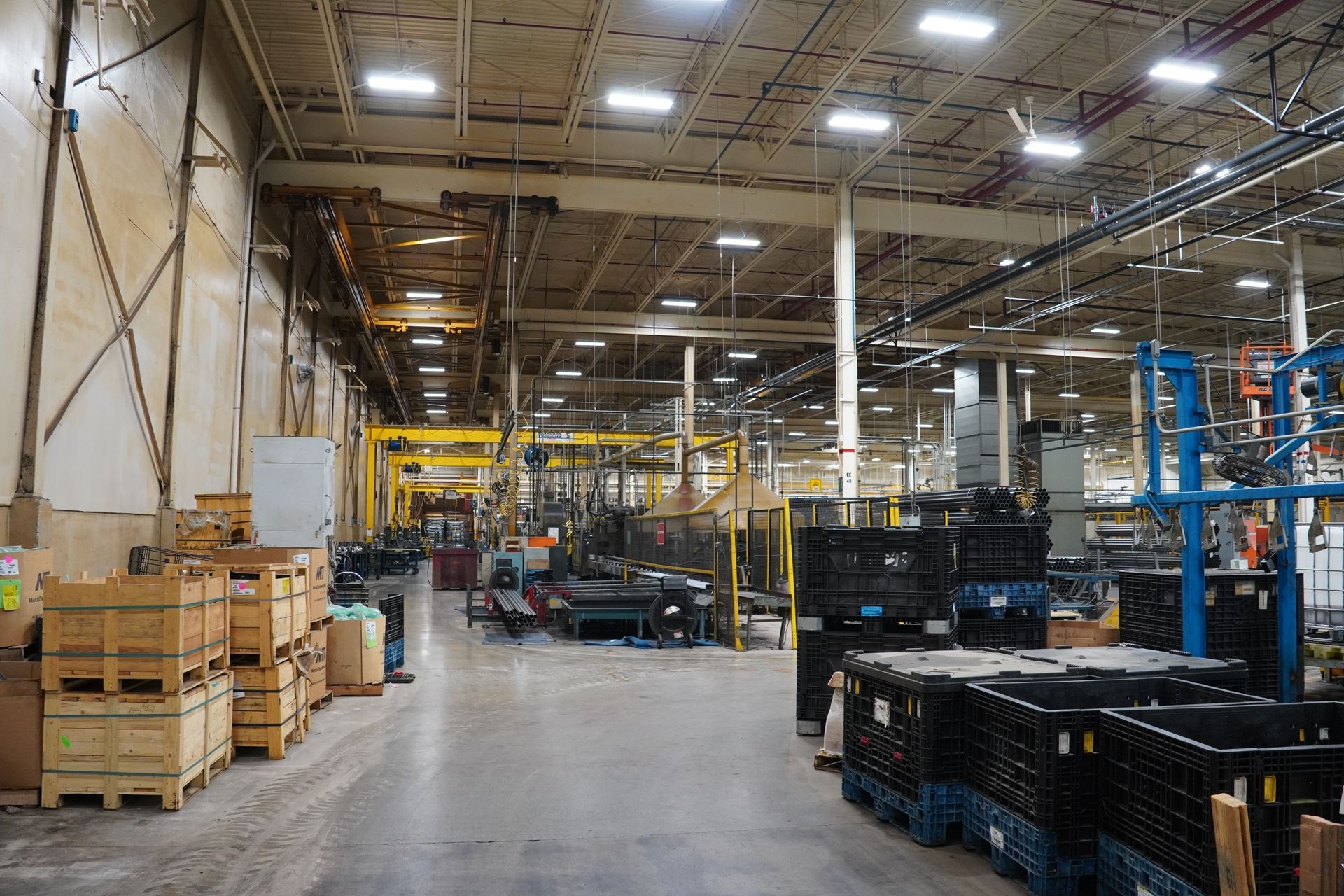 Electrician in orange helmet working on electrical panel, using tools.