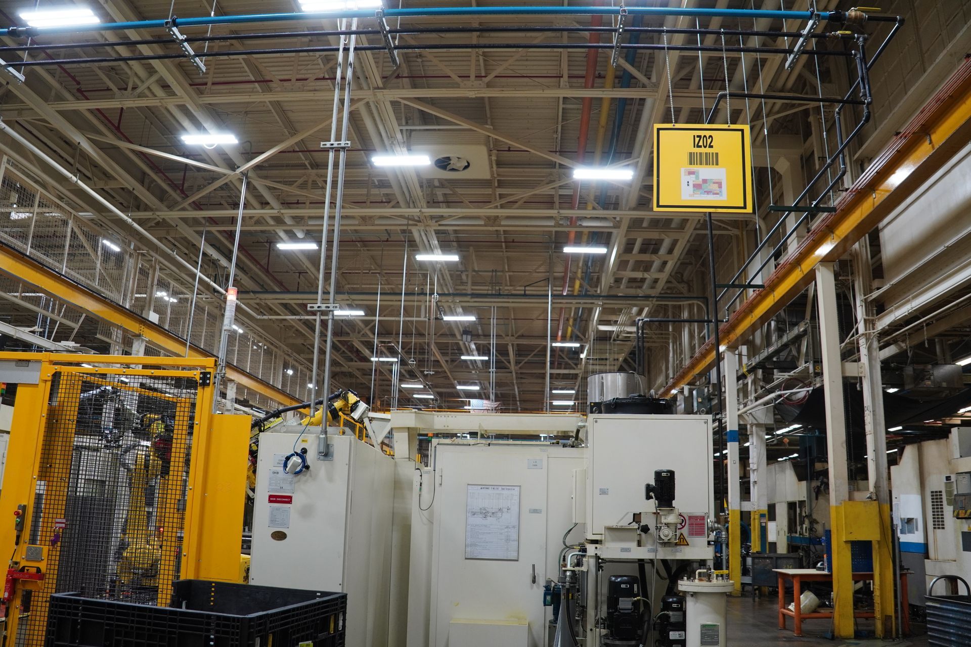 Person changing a lightbulb in a black lampshade, with green plants in the background.