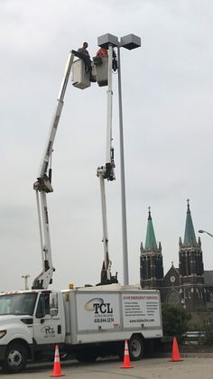 Electrician working inside an electrical panel wearing a hard hat, safety glasses, and gloves.