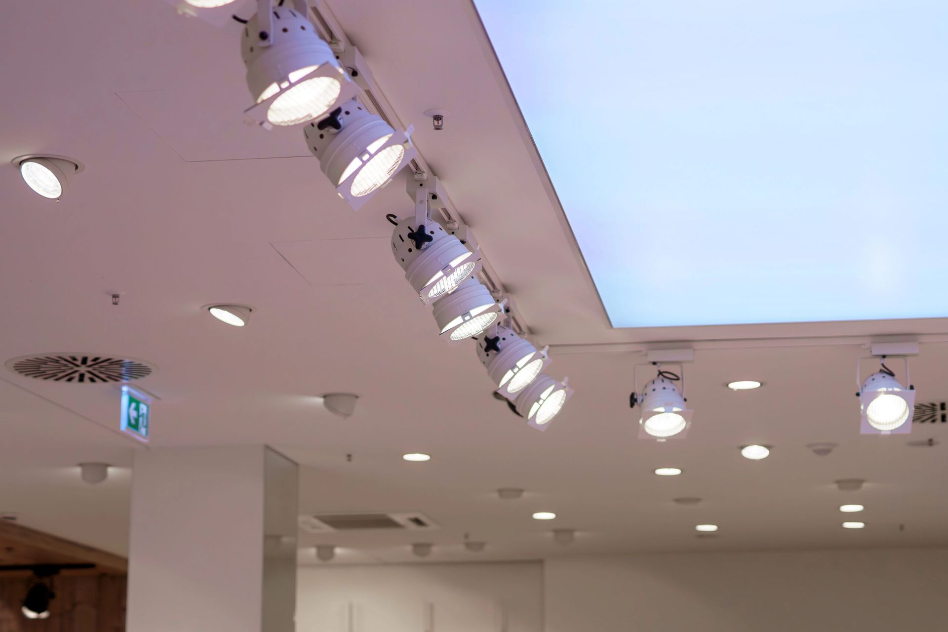 White ceiling with track lighting and recessed lights in a commercial space.