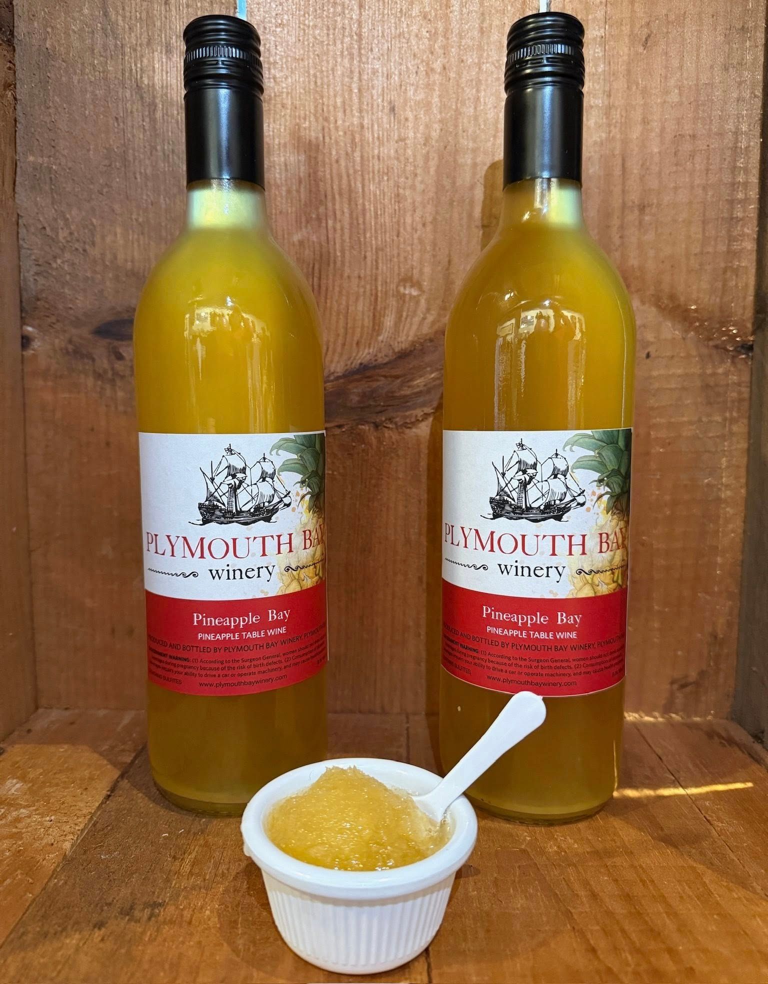 Two bottles of yellow liquid with labels, small cup of yellow granules with spoon.