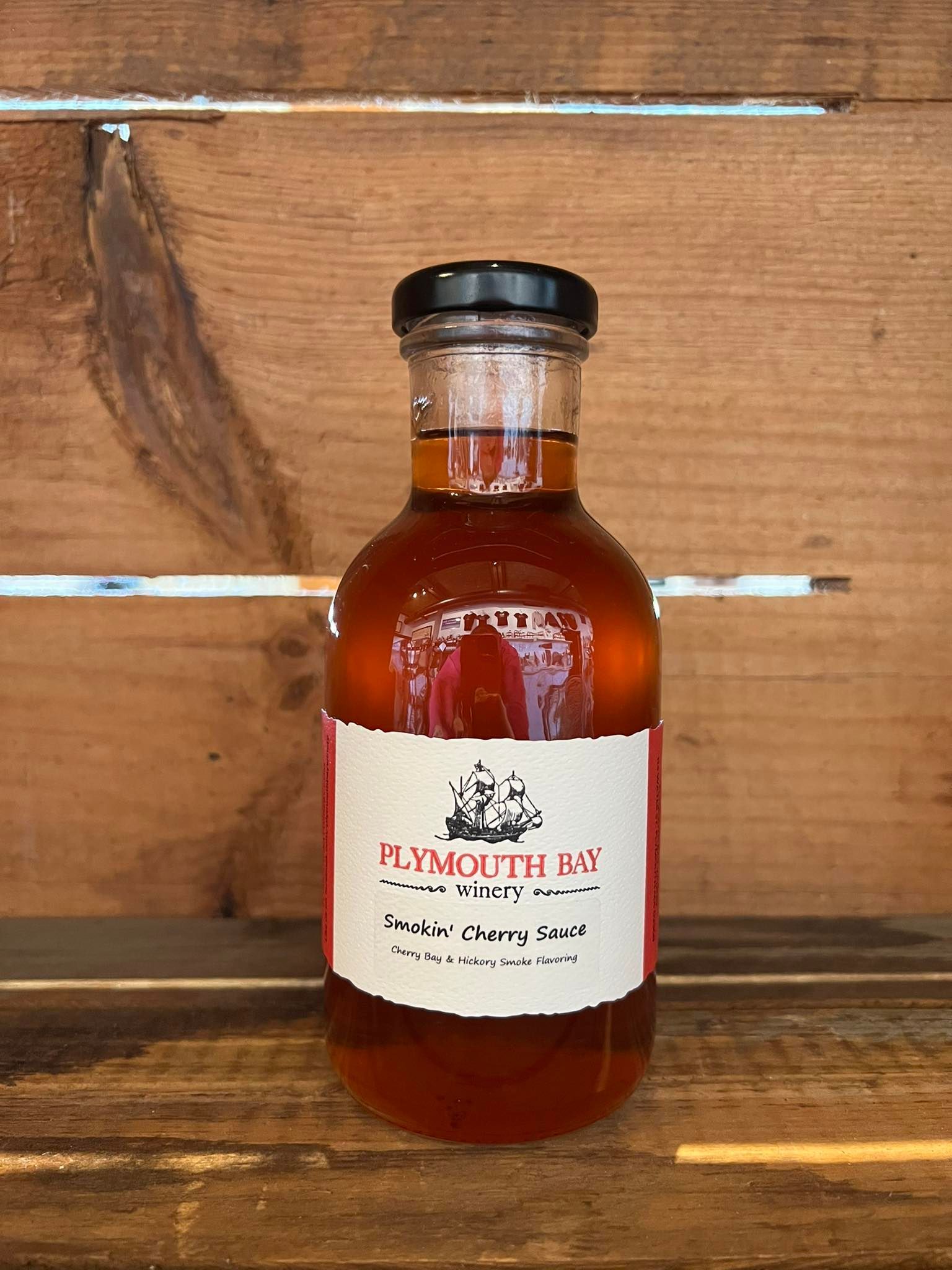 Bottle of Plymouth, MA maple syrup against a wooden background.