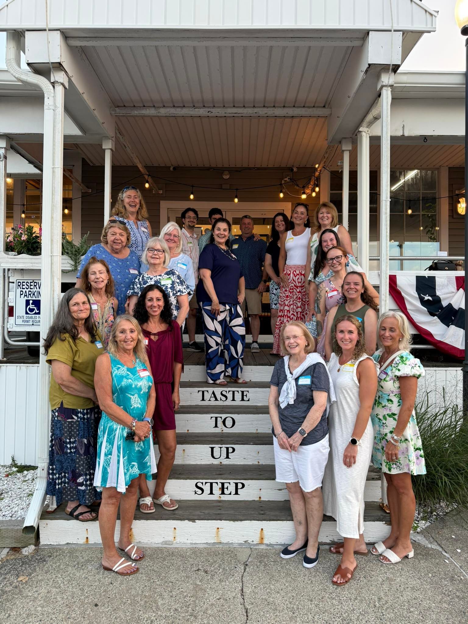 Group of people smiling on steps of a building, 
