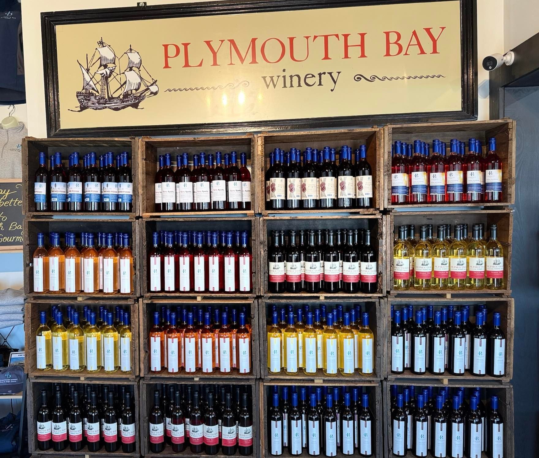 Plymouth Bay Winery wine bottles displayed in wooden crates.