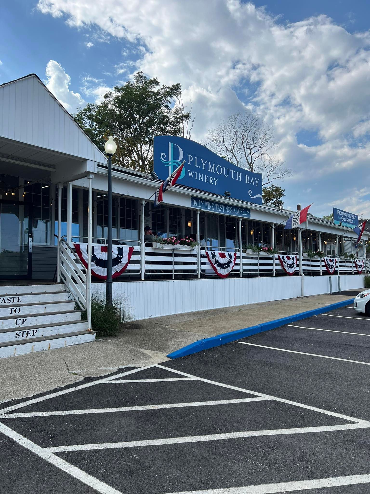 Diner with blue and white exterior, decorated with bunting, set in a parking lot under a cloudy sky.