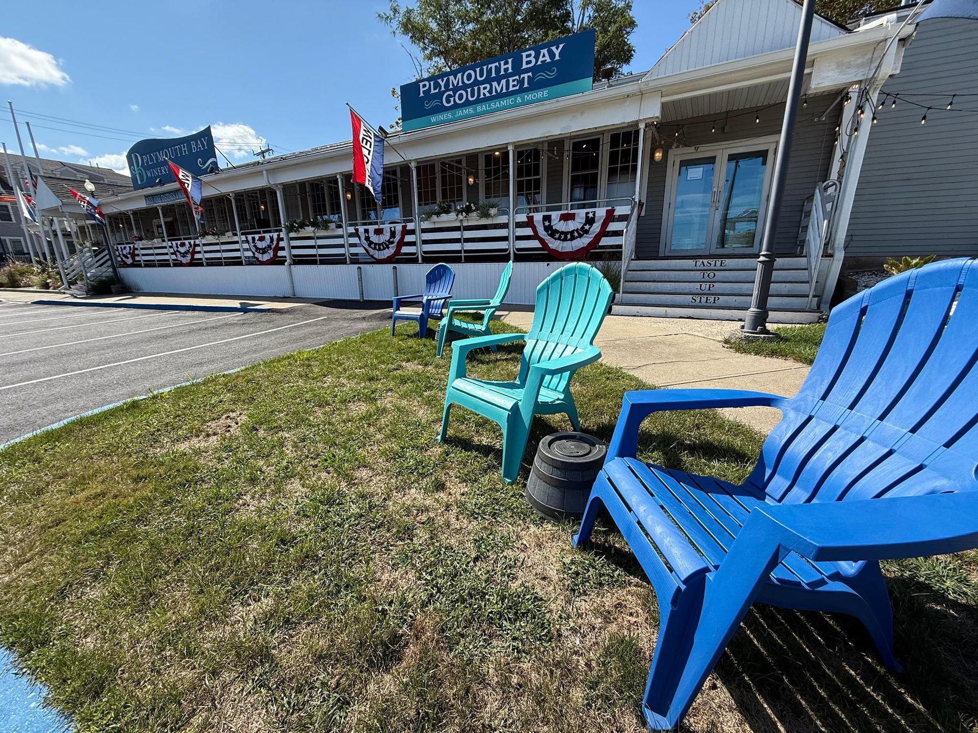 Plymouth Bay Lobster Co. building with blue and teal chairs on the lawn.