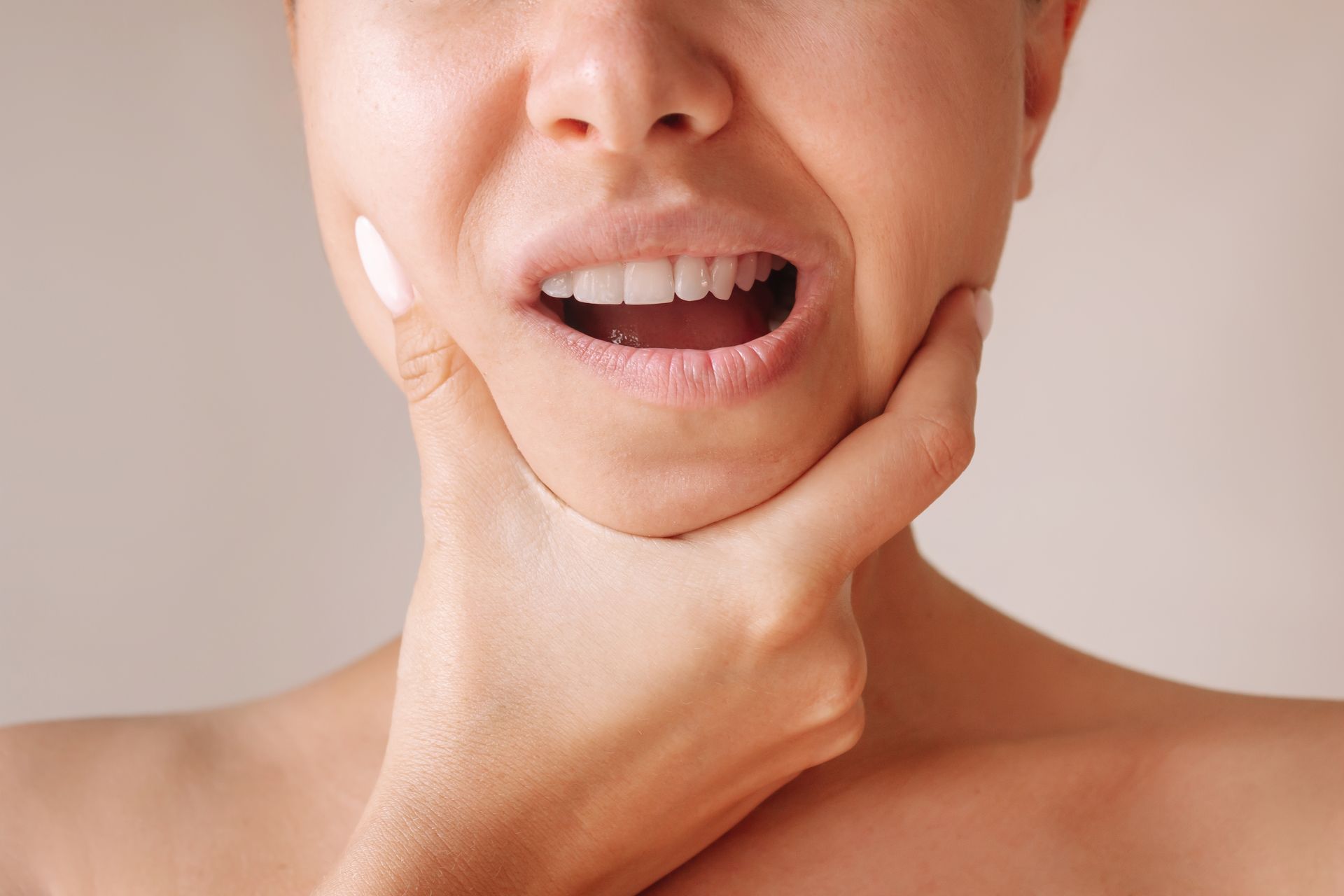 A woman is holding her face in pain because of a toothache.