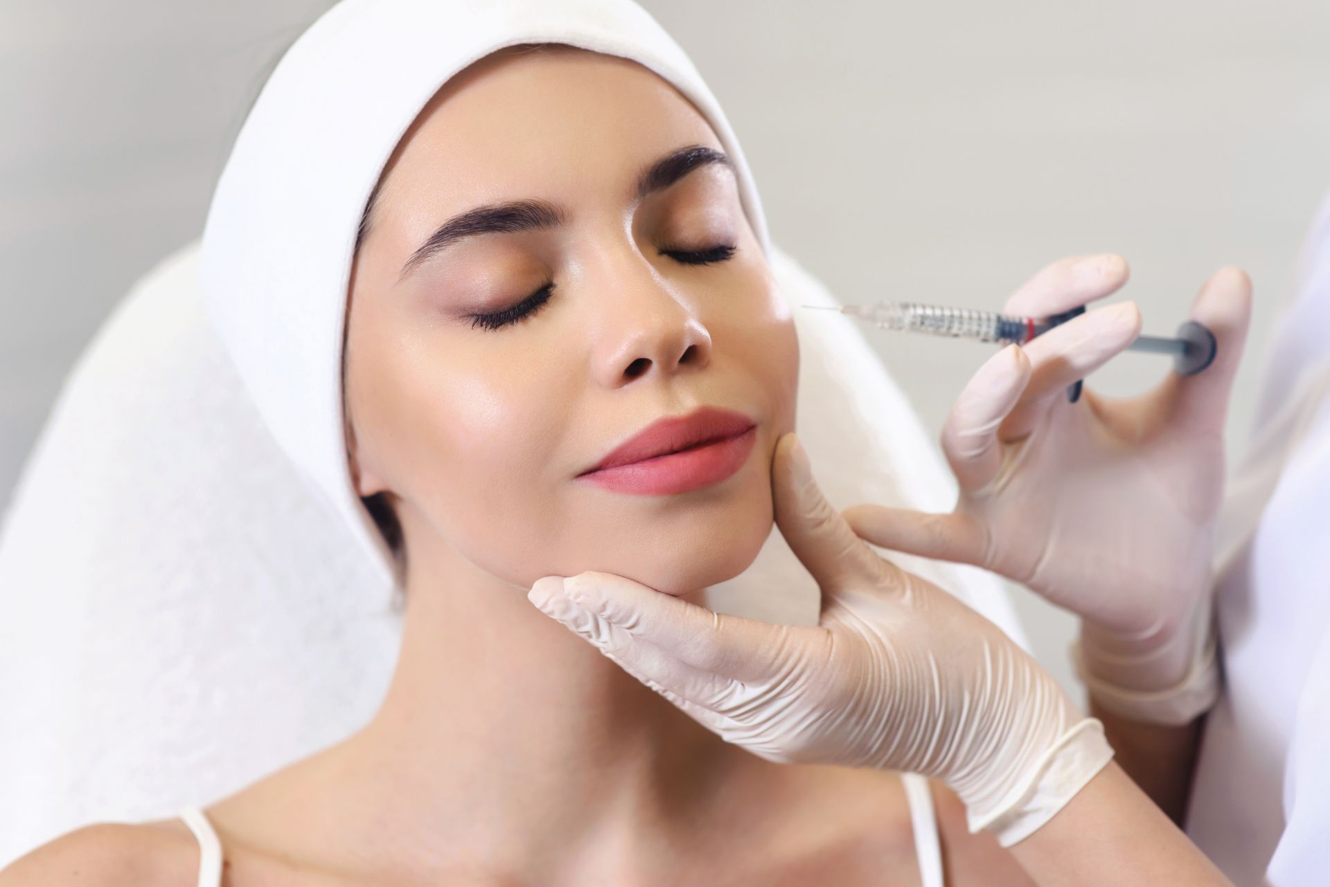 A woman is getting a botox injection in her face.