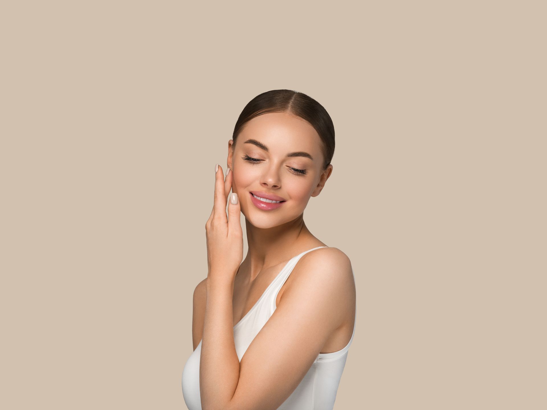 A woman is touching her face with her hand and smiling.