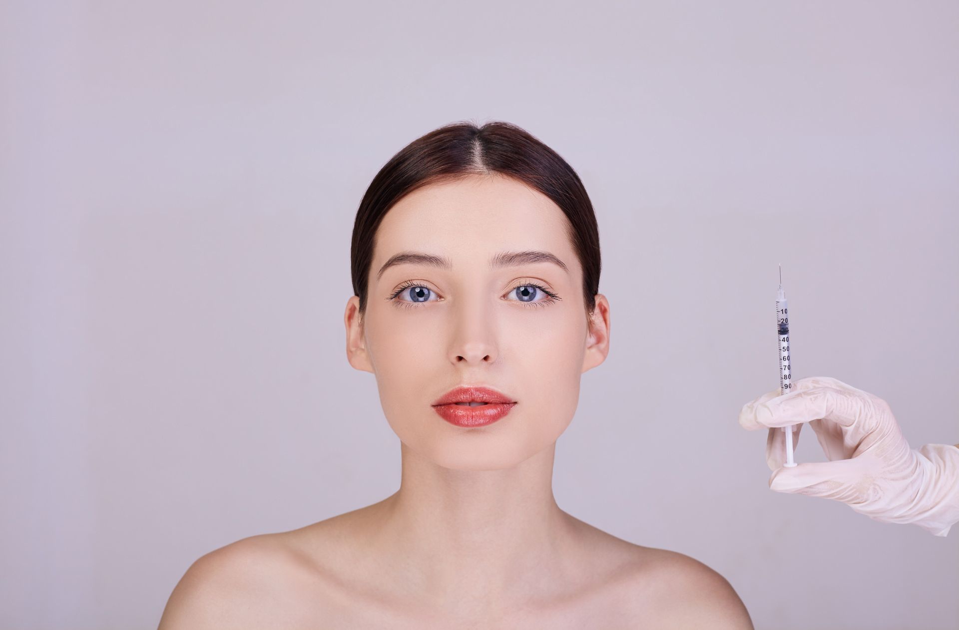 A woman is getting a botox injection in her face.